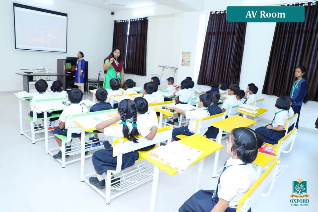 teachers giving presentaion to students in audio-visual room of school